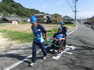 避難困難者の車椅子を押してサポートしている写真